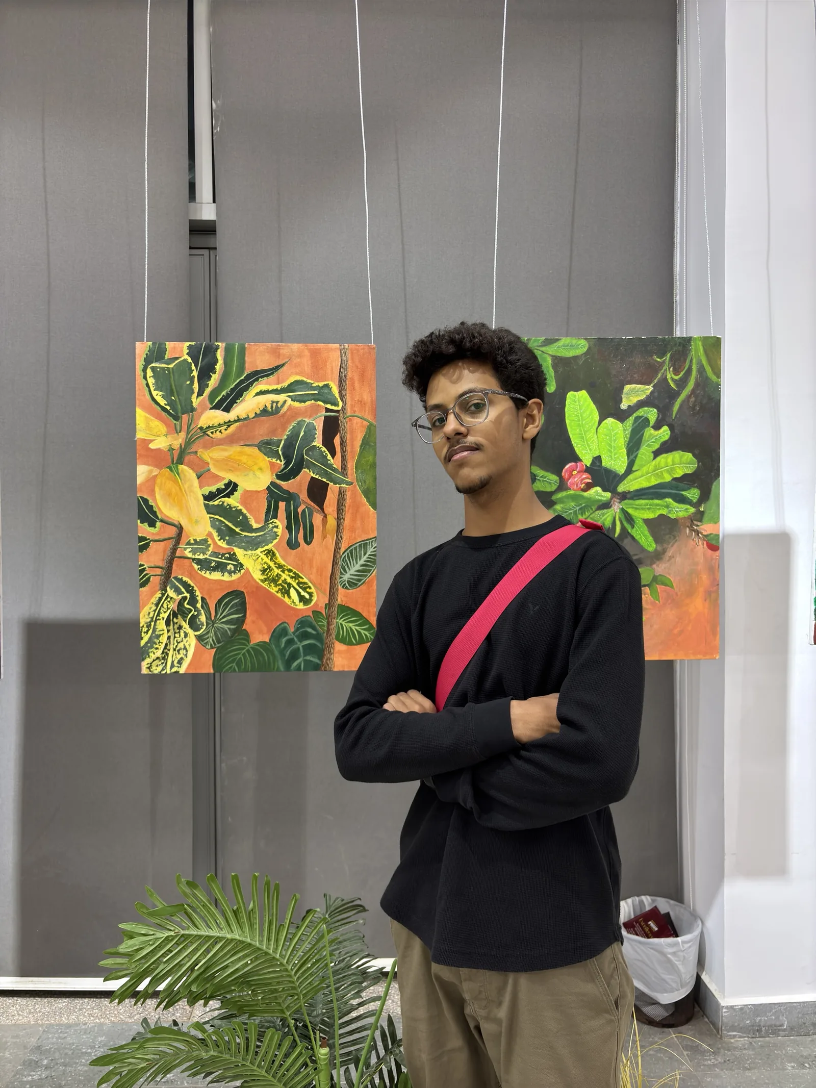 Feras standing next to the exhibited paintings