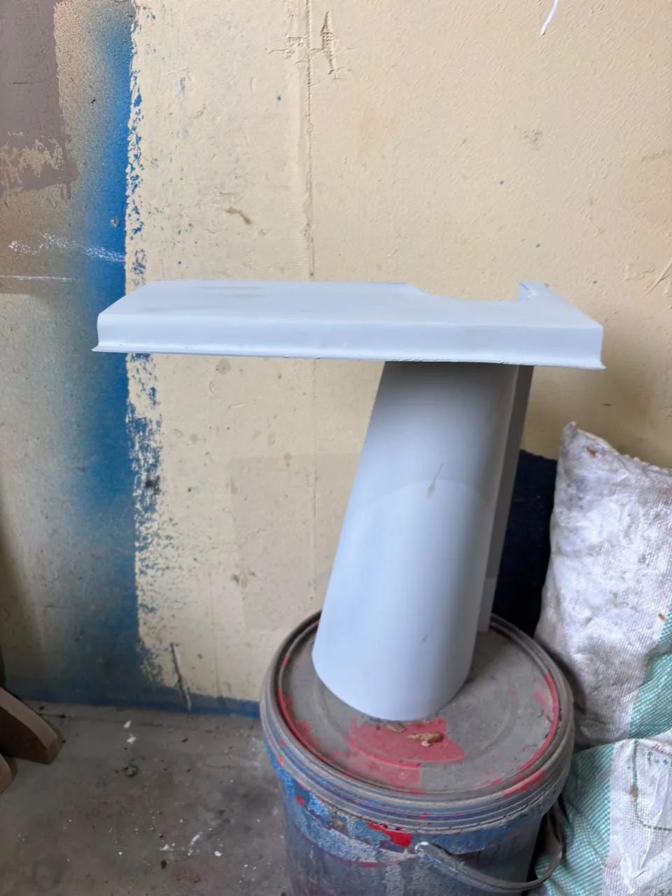 The bent and assembled lamp in grey primer in a workshop
